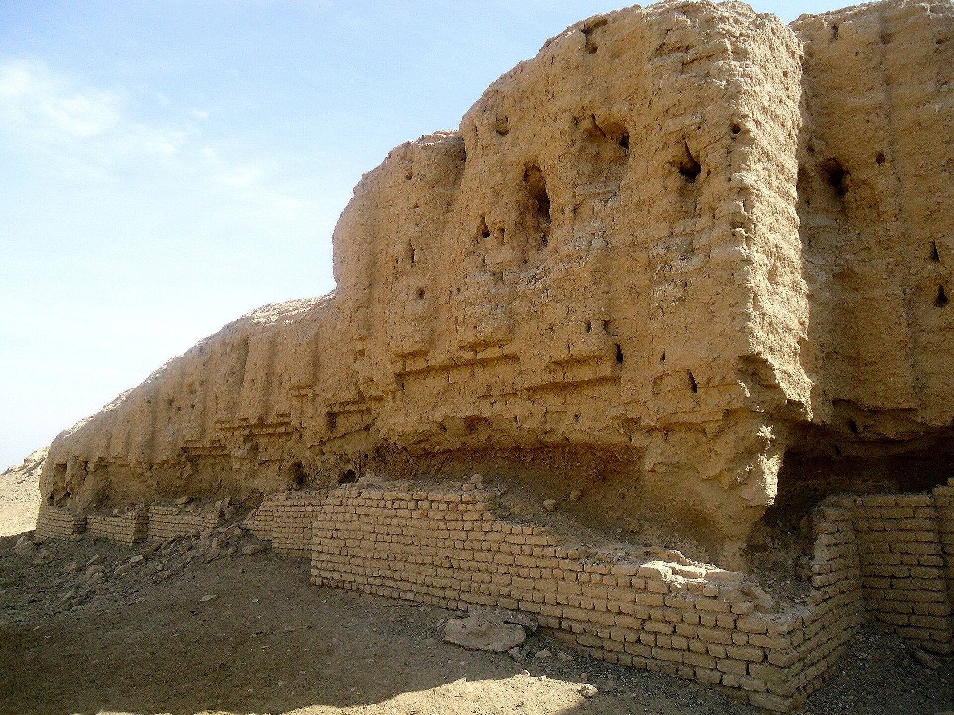 Eroded mud-brick ziggurat mound rising from flat land at Kish, Iraq