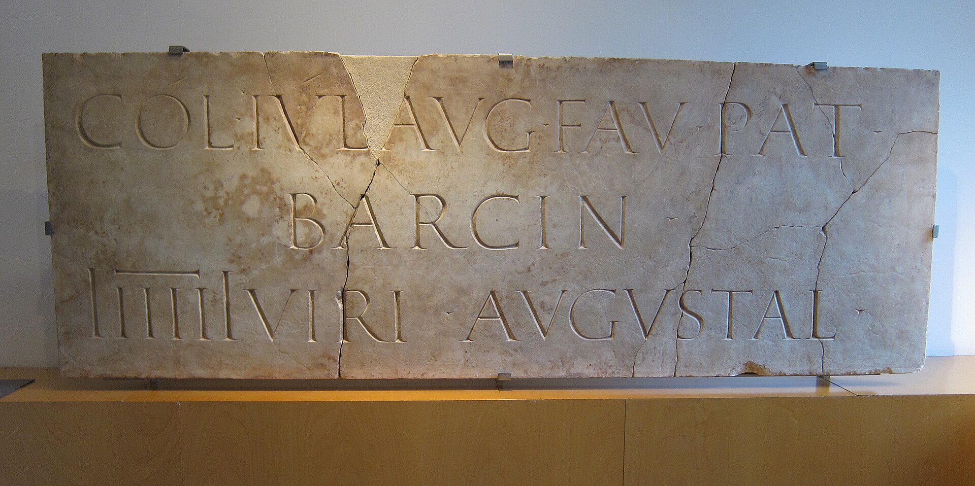 Marble slab with carved Latin letters naming the Roman colony of Barcino