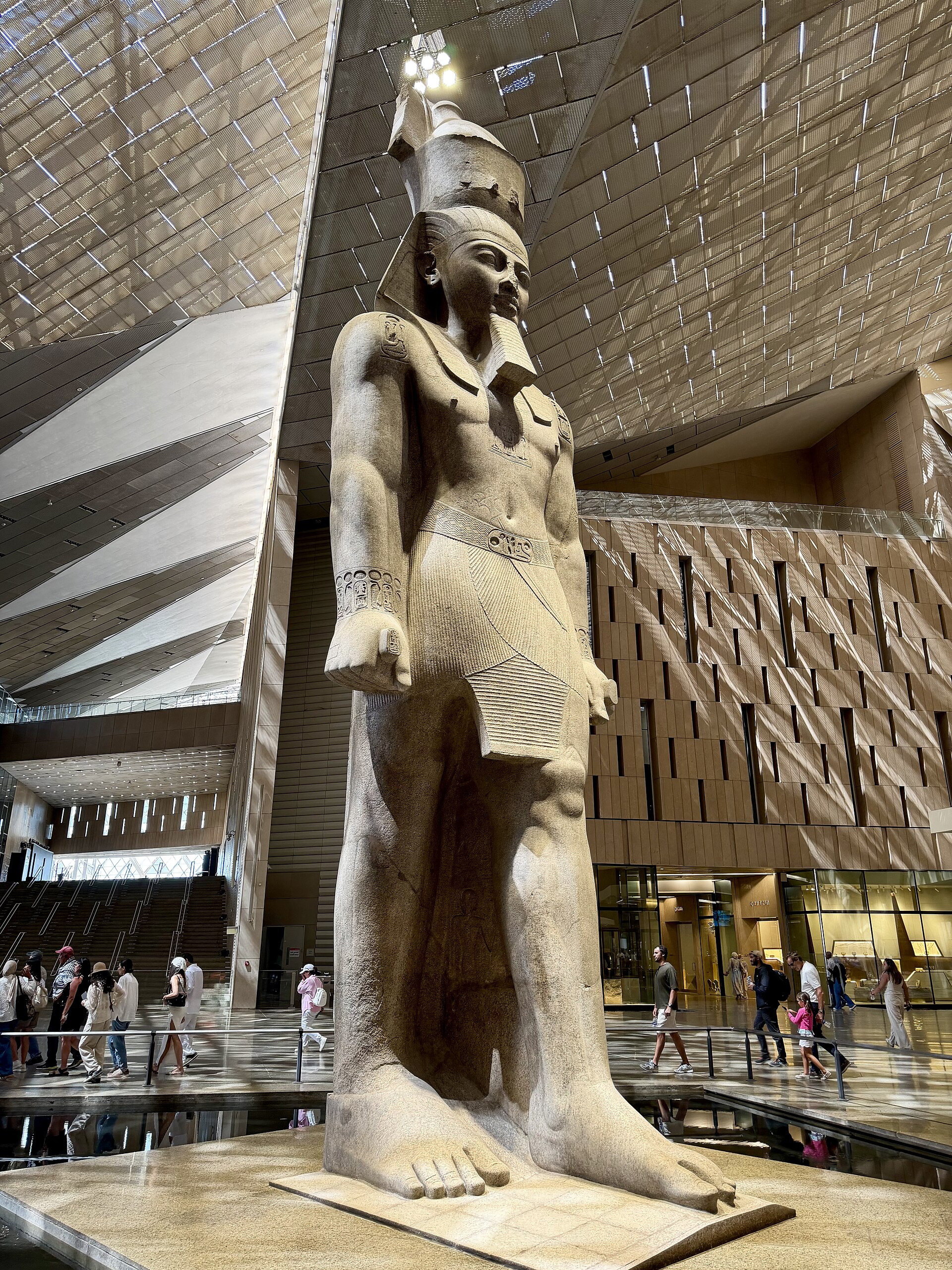 Giant standing stone statue of Pharaoh Ramesses II in a museum hall